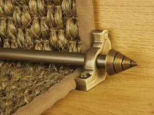 Arrow-shaped carpet rod with bracket, antique brass