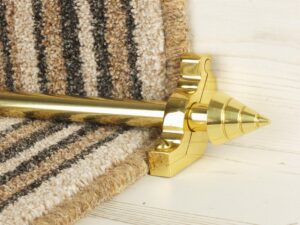 Arrow stair rod in polished brass on brown striped stair runner
