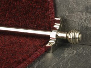 Sphere stair runner rod in polished nickel fitted to deep red stair runner on staircase