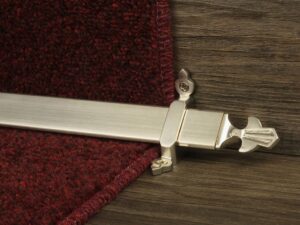 Louis design of stair rod with fleur-de-lys end, stain nickel on red carpet