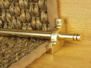 Balmoral runner carpet rod with matching bracket in polished brass attached to coir stair runner