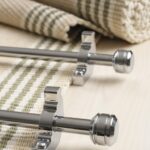 Piston stair rods polished chrome on striped, folded carpet