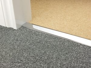 Premier DoubleZ door threshold joining two tufted carpets in chrome