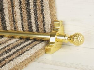 Extra large Dune stair rods on striped carpet