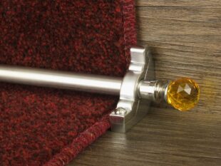 Chrome stair rod with amber crystal finial on red carpet