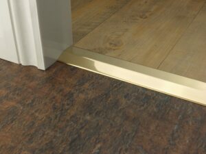 Premier 2 Way Ramp sloping door threshold, shown from laminate to vinyl, polished brass