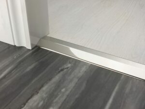 Premier 2 Way Ramp sloping door threshold, shown from laminate to vinyl, polished nickel