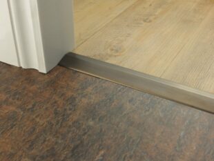Premier Ramp 10mm sloping door threshold, shown from laminate to vinyl in antique bronze