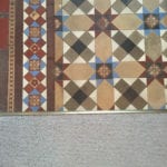Premier Z9 threshold transition strip in antique brass joining carpet to patterned tiled floor