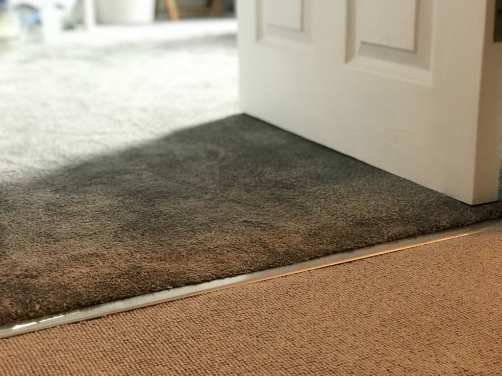 Satin nickel Premier ZZ9 carpet threshold strip joining brown and beige carpets