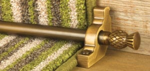 Arran thistle design of stair rod in antique brass fitted to green stripey stair carpet