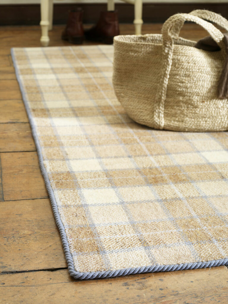 Grey Dunn easybind carpet binding tape around checked rug on wood floor with basket