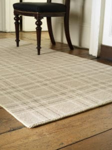 carpet edge binding in beige on a tartan rug with wooden chair