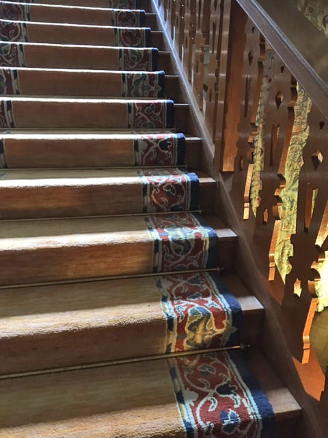 Period staircase fitted with tarnished antique brass stair rods