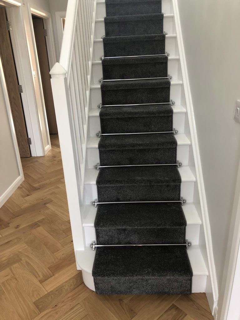 Polished chrome stair rods with sphere finials on charcoal stair runner