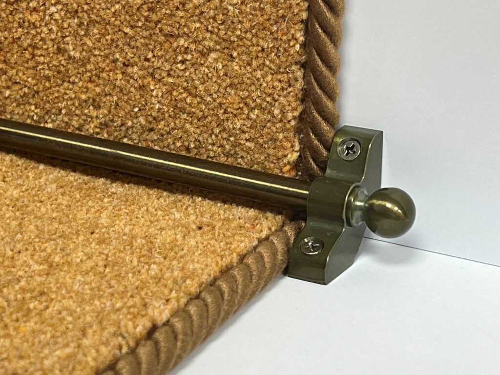 Bronze thin stair rod with ball end fitted on staircase